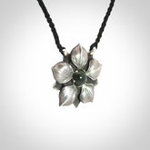 This is a hand carved Sterling Silver Manuka Flower pendant with New Zealand Jade insert. This is a medium sized necklace and is provided with an adjustable black cord.